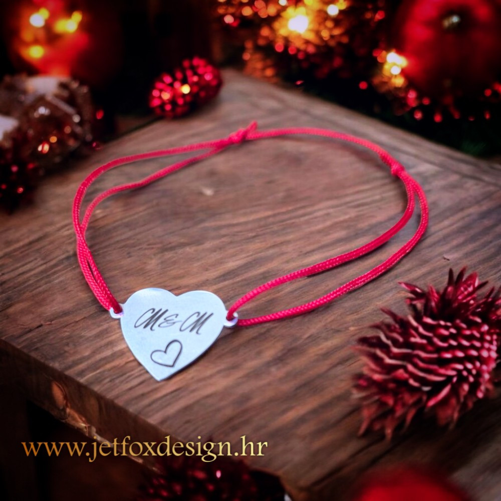 Narukvica s gravurom slike na srcolikom čeličnom privjesku, uz satenski konac u raznim bojama.
