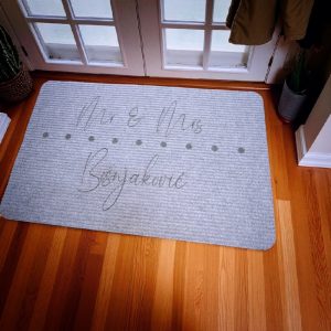 Otirač s natpisom "Mr & Mrs" i prezimenom, idealan za mladence ili bračni par koji ulazi u novi dom.