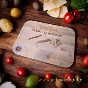 Drvena daska za rezanje s ugraviranim natpisom "Ivičina daska za rezanje" i motivima noža, slanine i kobasice.