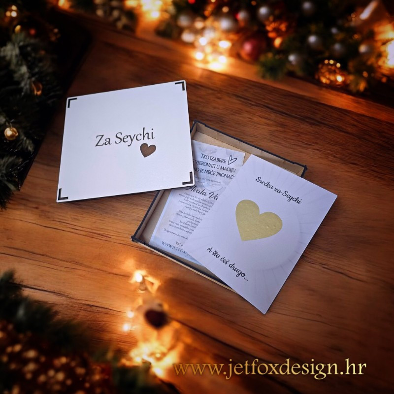 Personalizirana strugalica srebrne boje u obliku srca, s imenom i skrivenom porukom za buduću kumu.