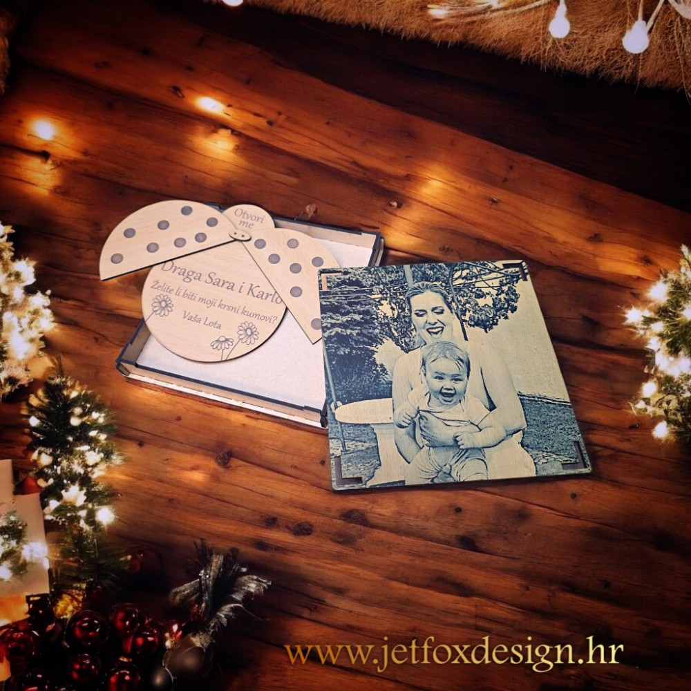 Drvena čestitka s motivom bubamare koja skriva pitanje za kumstvo ispod njezinih krila – personalizirani poklon.