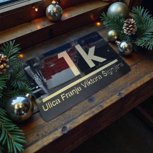 Elegantni kućni broj s personalizacijom po želji, sjajna crna podloga sa zlatnim slovima za luksuzan izgled fasade.