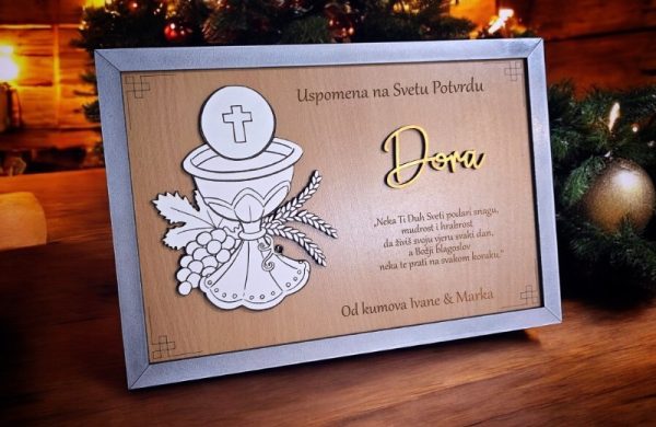 Personalizirani okvir uspomena s motivom kaleža i imenom slavljenika, poklon od kuma za svetu potvrdu (krizmu). Neka krizma ostane u sjećanju uz ovaj jedinstveni dar.