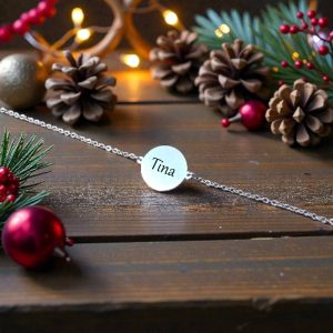 Narukvica s okruglim srebrnim privjeskom na lančiću i imenom na obje strane, elegantan personalizirani poklon.