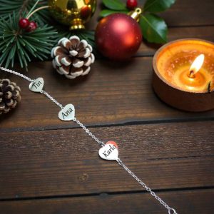 Narukvica s tri srebrna privjeska srca s imenima, emotivan poklon za obitelj ili voljene osobe.