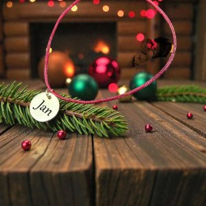 Personalizirana satenska narukvica s visećim privjeskom u obliku kruga i imenom, diskretan detalj za svaki dan.