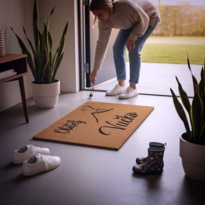 Otirač s prezimenom obitelji i kućicom kao topla dobrodošlica ispred kuće ili stana