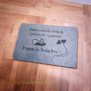 Personalizirani otirač s ilustracijom mačke i srca te prezimenom obitelji – tražite li otirač koji odmah pokazuje karakter doma?