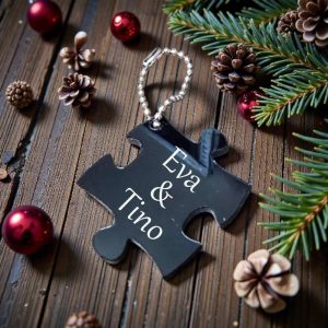 Privjesak u obliku puzle s tekstom i fotografijom, mali detalj koji predstavlja važnu uspomenu.