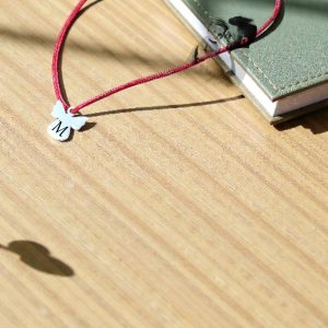 Satenska narukvica s minimalističkim privjeskom anđela i obostrano graviranim inicijalom, nježan osobni poklon.