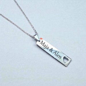 Ogrlica sa srebrnim kvadratnim privjeskom, obostrano gravirana imenima i izbušenim srcem kao ljubavni detalj.