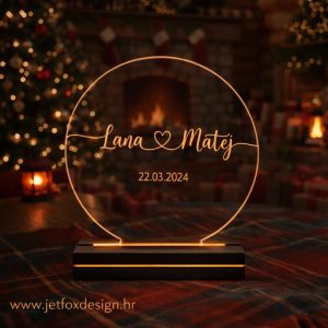Akrilna lampa u obliku kruga s imenima Lana i Matej i datumom 22.03.2024. u toplom ambijentu uz kamin – tražite li romantičan poklon za godišnjicu?