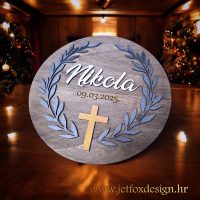 Drvena dekoracija s graviranim imenom i datumom, ukrašena maslinovim granama i križem, trajna uspomena na krštenje i sakramente.